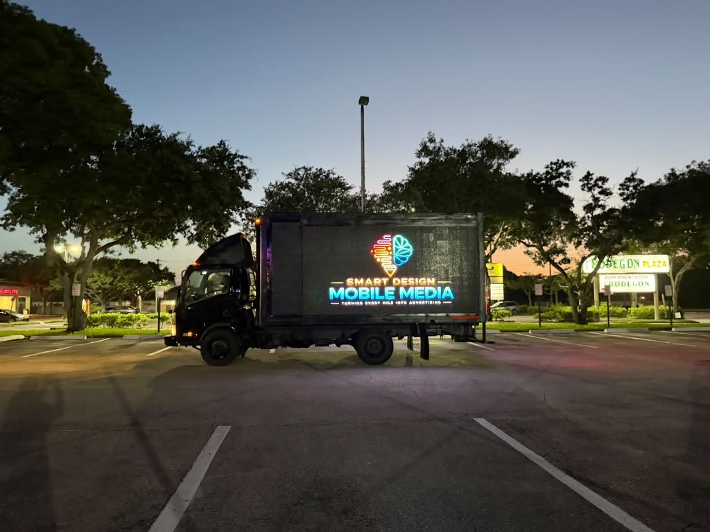 LED billboard truck, side screen lit at dusk in West Palm Beach